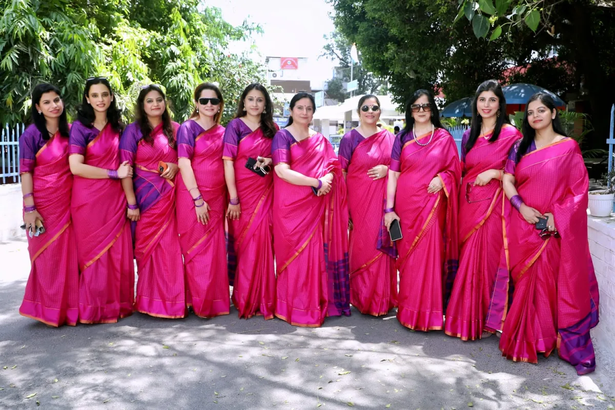 The Jammu Menopause Society organising team in coordinated pink sarees, gathered in a garden.