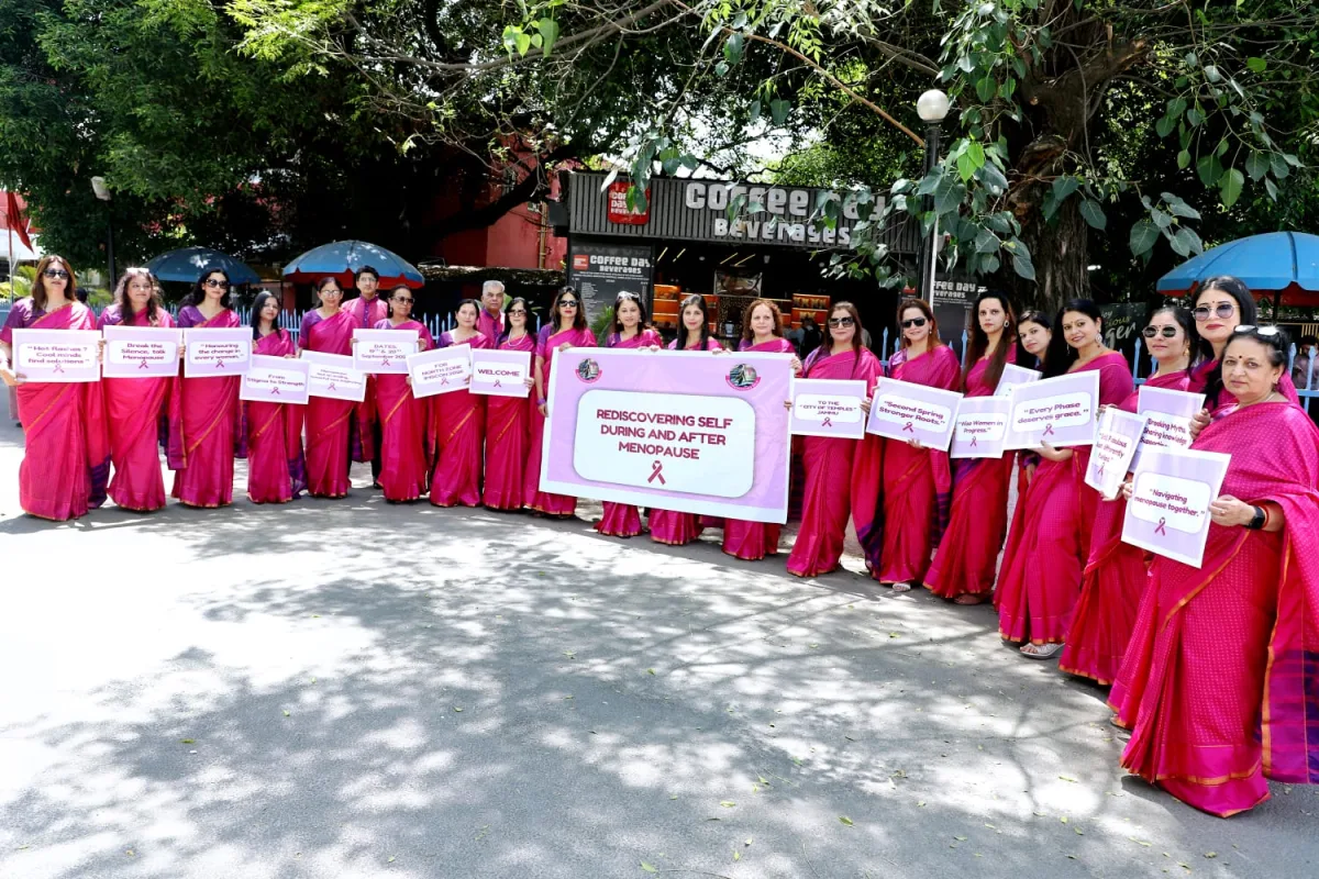 Members of the Jammu Menopause Society organising team in coordinated pink sarees, holding awareness placards — the central one reading ‘Rediscovering Self During and After Menopause’.